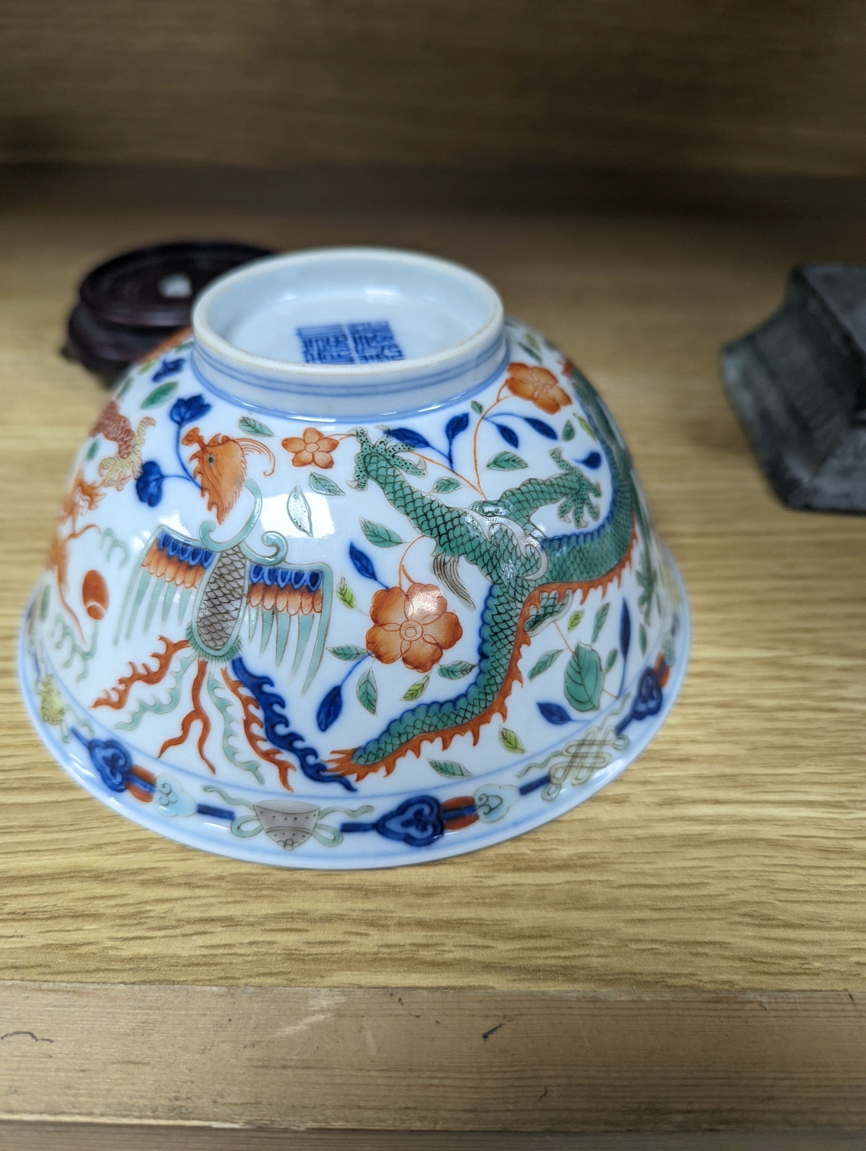 A Wucai bowl, dragon and flamingo pearl decoration, Jiaqing mark, on wood stand. 16cm diameter